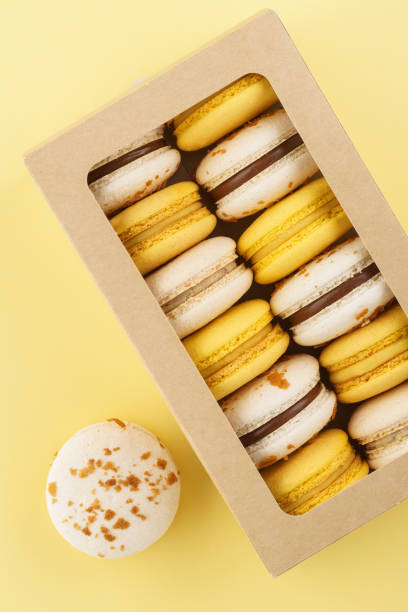 istock Colorful macarons in a gift box on yellow background. 1141428701