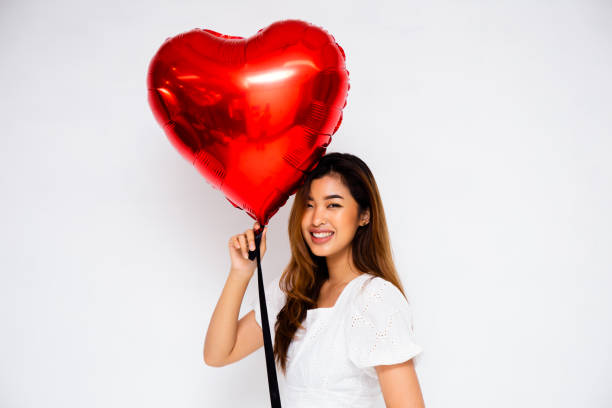 istock Smiling Asian female with heart balloon 1141430572