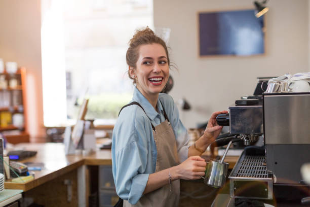 Barista at work Young barista preparing coffee for customers at her cafe counter barista photos stock pictures, royalty-free photos & images