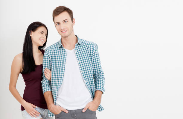 istock Happy couple embracing and looking camera on white background 1141432177