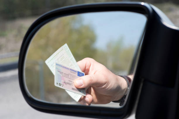 um homem mostra carteira de motorista e licença de veículo durante um cheque - ticket control - fotografias e filmes do acervo