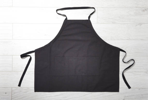istock Black apron for kitchen top view on white wooden background. 1141434019