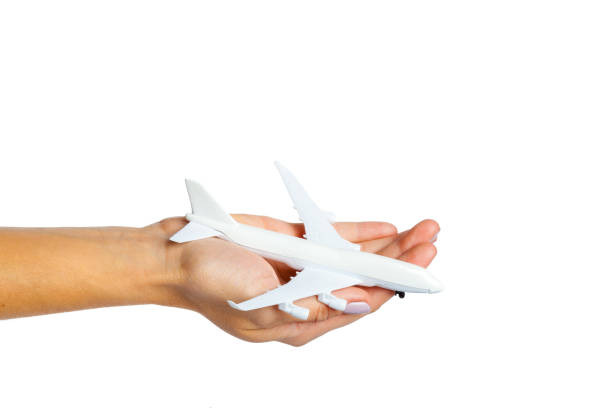 istock hand holding airplane toy model isolated on white background 1141435996