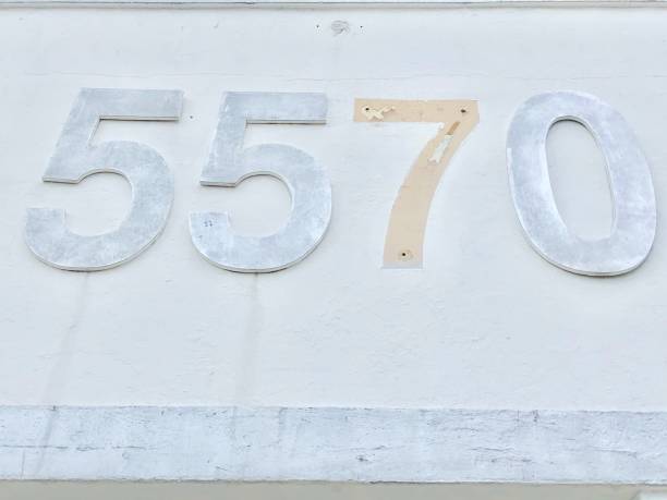 istock Numbers 5570 on white  concrete wall with missed number 7 1141437329
