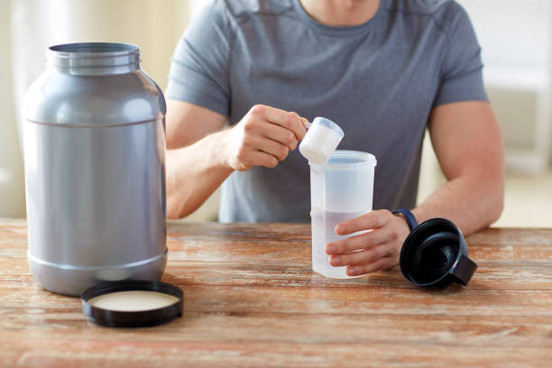 istock close up of man with protein shake bottle and jar 1141437448