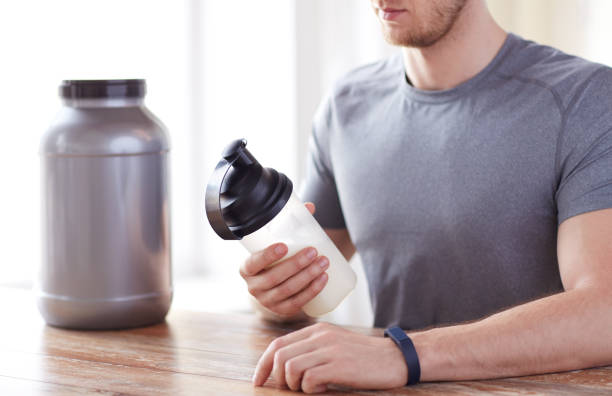 istock close up of man with protein shake bottle and jar 1141437469