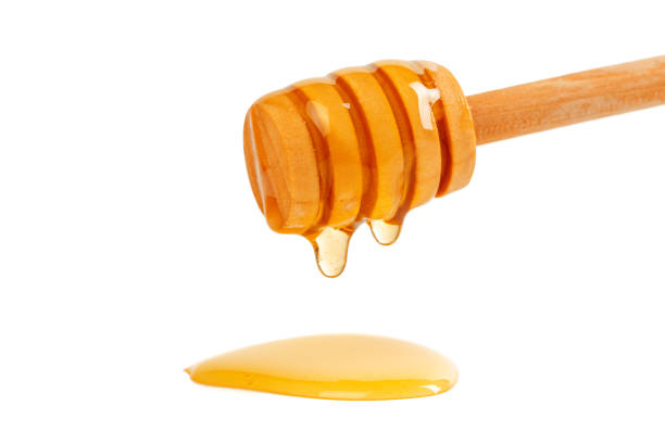 istock honey with wooden drizzler isolated on white background 1141437628