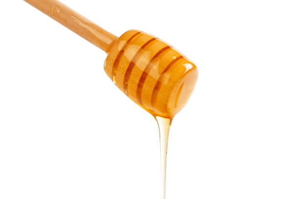istock honey with wooden drizzler isolated on white background 1141438146