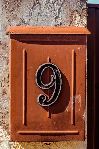 istock Red painted steel mail box with number nine on concreate fence. 1141440762