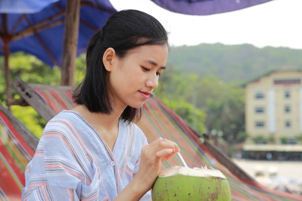 young woman drink coconut juice in Samson beach ,Vietnam