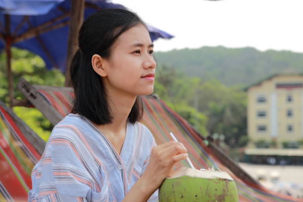 young woman drink coconut juice in Samson beach ,Vietnam