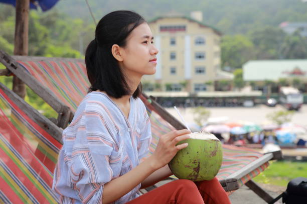 young woman drink coconut juice in Samson beach ,Vietnam