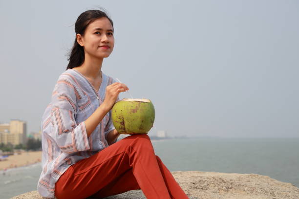 young woman drink coconut juice in Samson beach ,Vietnam