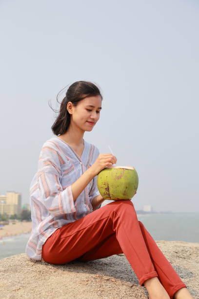 young woman drink coconut juice in Samson beach ,Vietnam