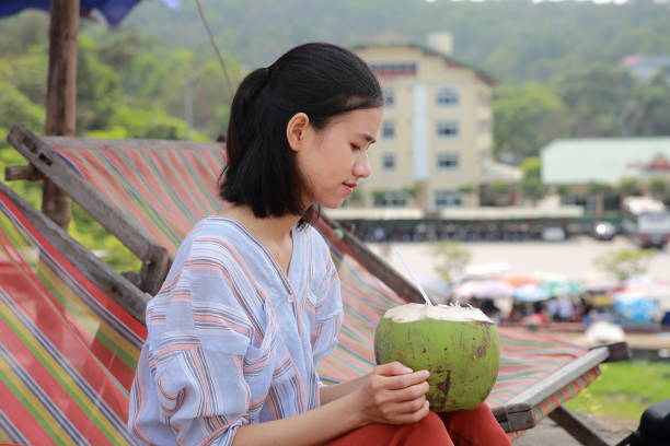 young woman drink coconut juice in Samson beach ,Vietnam