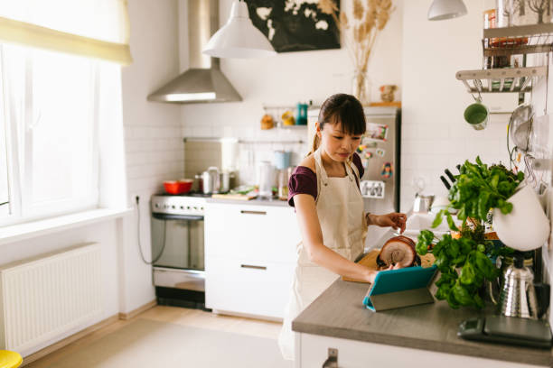 istock Asian woman fusing digital cookbook at home 1141441721