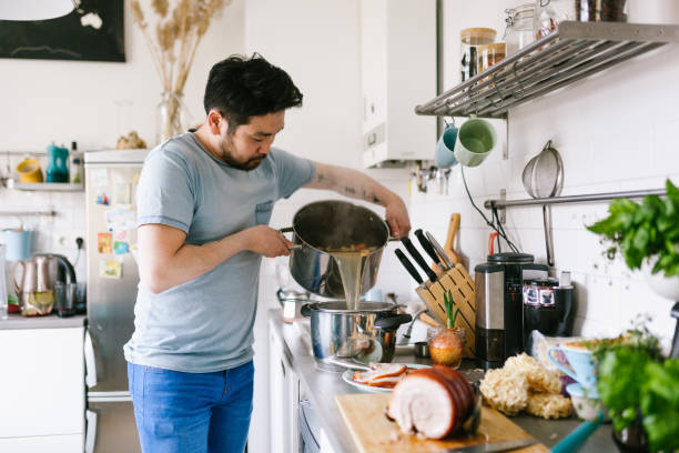 Asian man making ramen soup broth