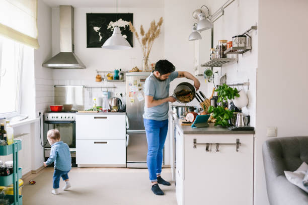 子供と一緒に、家庭でラーメンスープを作るアジア人 - two parent family indoors home interior domestic kitchen ストックフォトと画像