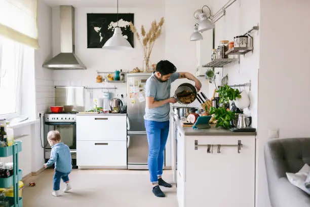 Photo of Asian man with his child making ramen soup at home