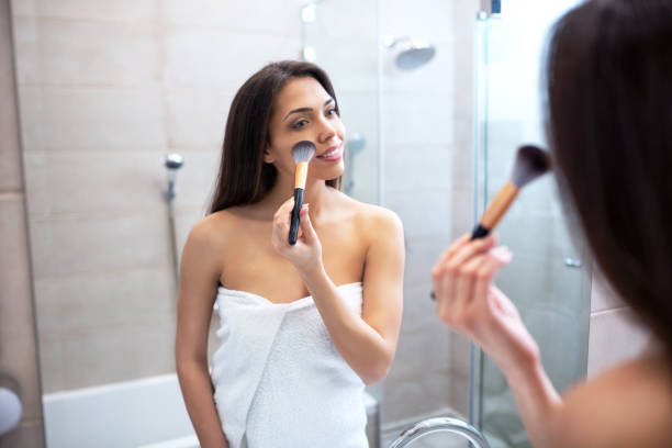 istock Pretty girl applying some makeup on her face 1141442856