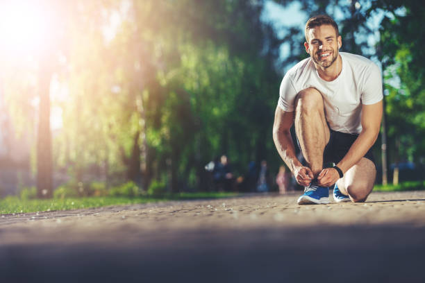 istock Cheerful athlete is tying his trendy shoelaces 1141443511