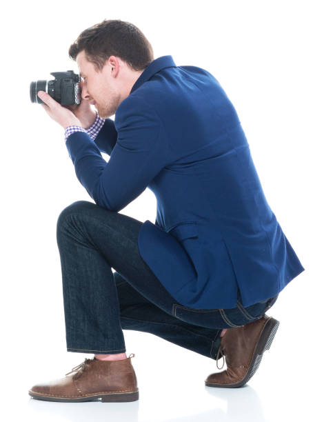 istock Side view of handsome man crouching while holding DSLR camera 1141449381