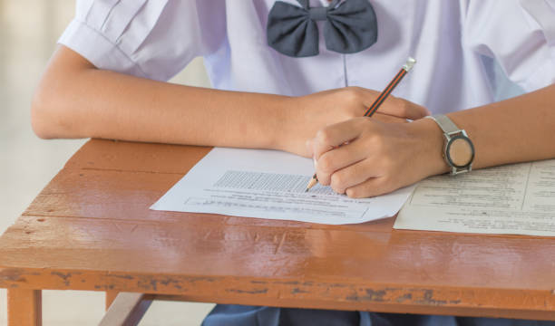 students writing a test exercise, exam paper and multi-choice in classroom, uniform student in Thailand. students writing a test exercise, exam paper and multi-choice in classroom, uniform student in Thailand. SINGAPOREAN SECONDARY EXAM stock pictures, royalty-free photos & images