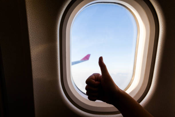 istock Plane wing view from inside plane in midair with blue sky cloud background 1141449701