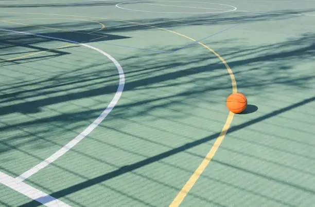 Closeup of orange ball for basketball on the rubber sport court.Sport ground outdoor in the yard