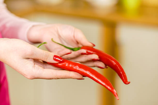 istock Woman holding chilli hot pepper 1141450711
