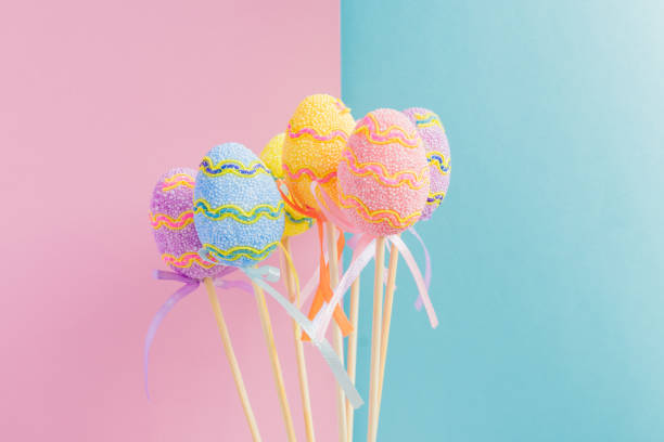 istock Easter colorful decorated eggs stand on a sticks on light blue and pink background. Minimal easter concept. Happy Easter card with copy space for text. 1141450800