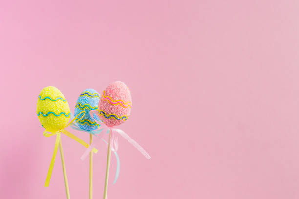 istock Easter colorful decorated eggs stand on sticks on pastel pink background. Minimal easter concept. Happy Easter card with copy space for text. 1141450870