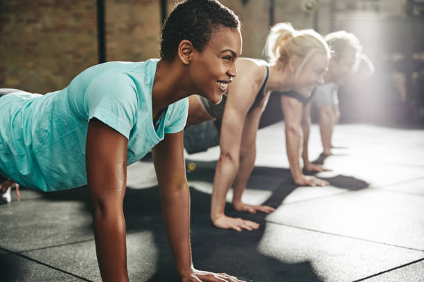 istock Young woman smiling while doing pushups at the gym 1141451493