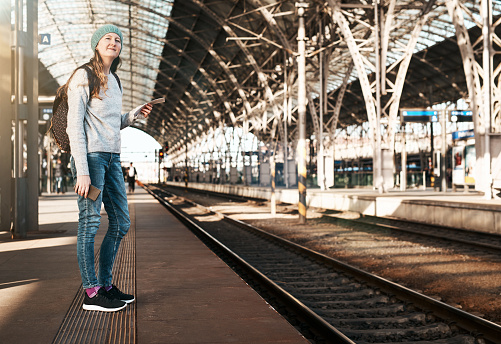Full length shot of an attractive young woman waiting for a train at the station