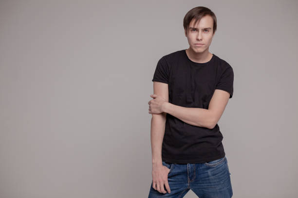 istock White young man in a black T-shirt and jeans. Emotion. 1141453368