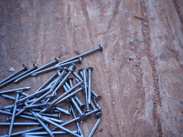 istock close up iron nails on old wooden table in construction site. building construction and industry concept 1141454994