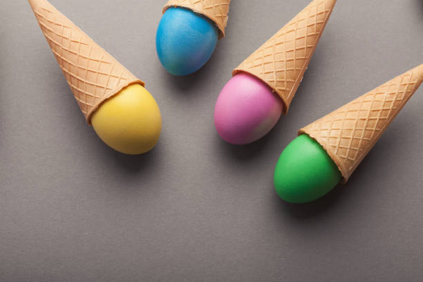 istock Colorful easter eggs in waffle cones on gray background 1141456445