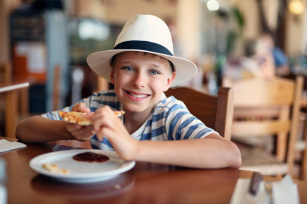 istock Little boy enjoying pizza in restaurant 1141456968