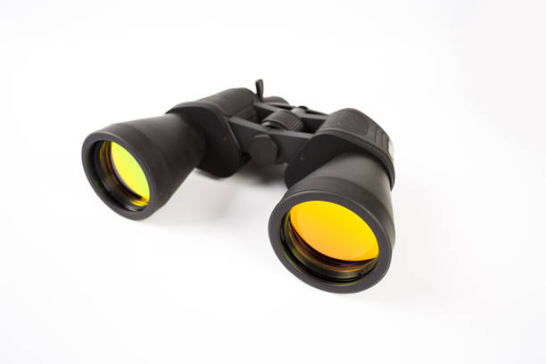 istock Black binoculars with orange lens isolated on white background 1141458092