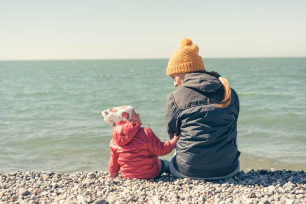istock Mother and daughter are sitting on the beach 1141458663
