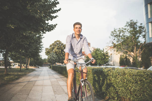 istock Cute young man riding a bicycle 1141458960