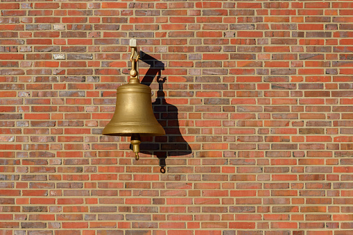 image of bell hanging on a brick wall