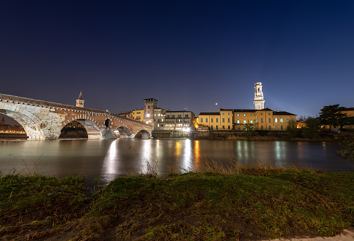 Ponte Pietra at night (Stone bridge). I century B.C. - the oldest Roman monument in Verona, UNESCO world heritage site, and the Adige river, Veneto, Italy, Europe