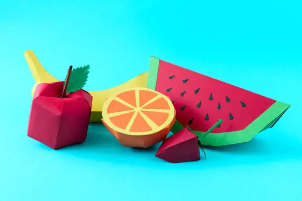 Photo of Apple, strawberry, banana, orange and watermelon made from paper on blue background. Fresh fruits. Minimal, creative, vegan, healthy or food art concept. Copy space.