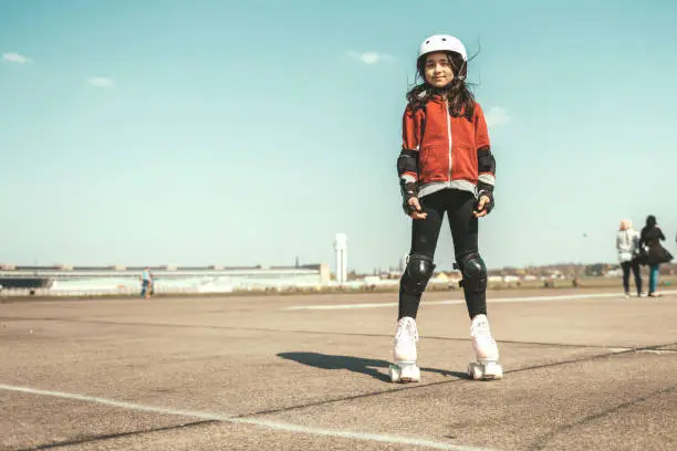 portrait view on little girl on roller skates on Tempelhofer Feld in Berlin