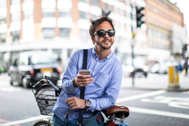 istock Man on bicycle using smart phone in London 1141460924