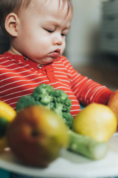 istock Baby boy playing with fresh fruit and vegetables 1141462447