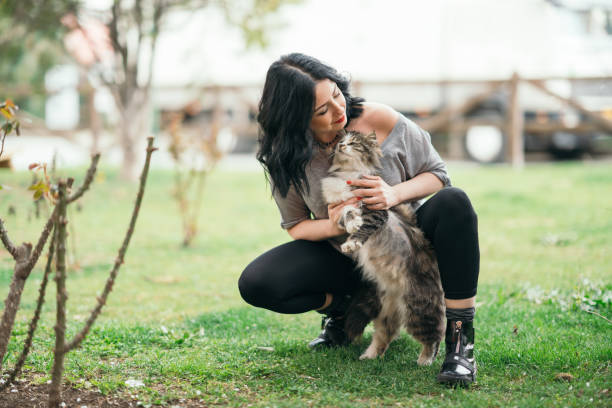 istock Smiling woman cuddling cat in nature 1141462666