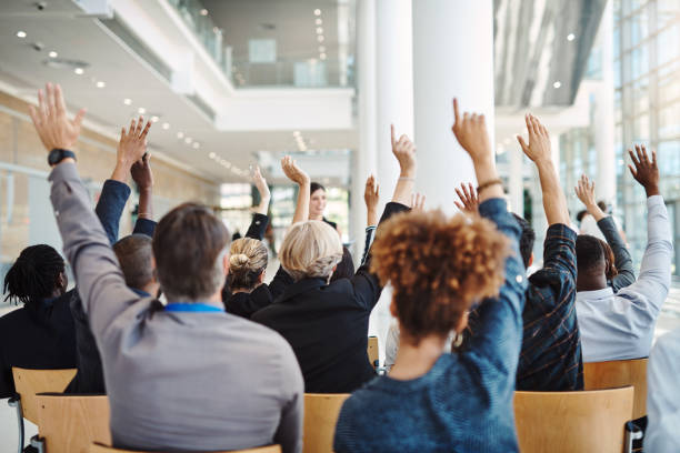 It's up to you to learn something new Rearview shot of a group of businesspeople raising their hands to ask questions during a conference arms raised stock pictures, royalty-free photos & images