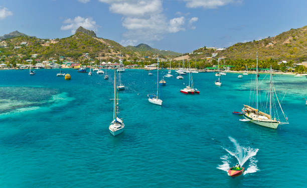 yachts at anchor sailing yachts anchoring in the turquoise waters behind the reef of Union Island, St Vincent and Grenadines, West Indies barbados stock pictures, royalty-free photos & images